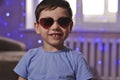 Fashionable little boy in sunglasses. stylish kid in blue shirt. fashion children. cool children. party at home Royalty Free Stock Photo