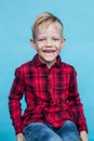 Fashionable little kid with red shirt. Fashion. Style. Studio portrait over blue background
