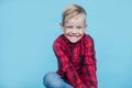 Fashionable little kid with red shirt. Fashion. Style. Studio portrait over blue background Royalty Free Stock Photo