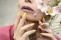 Fashionable makeup and yellow manicure .