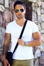 Fashionable man wearing satchel bag, watch ans sunglasses .