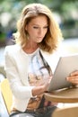 Fashionable mature woman connected on tablet