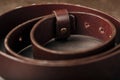 Fashionable men`s brown belt made of genuine leather with a light metal buckle on a dark background. Genuine leather, handmade Royalty Free Stock Photo