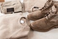 Fashionable mens autumn-spring beige suede boots with a stylish knitted sweater on a white table. Trendy classic look in a pastel