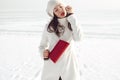 Fashionable model in white coat near winter sea Royalty Free Stock Photo