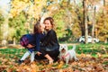 Fashionable mother and schoolgirl walking with their dog in park. Autumn time, weekend and holidays Royalty Free Stock Photo