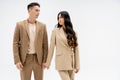 fashionable multiethnic couple in beige suits