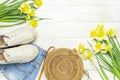 Fashionable natural organic round rattan bag, denim shorts, beige women`s espadrilles, yellow narcissus daffodil flowers on light