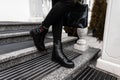 Fashionable new collection of autumn-winter women`s shoes. Close up of female legs in vintage jeans in black stylish boots with a Royalty Free Stock Photo