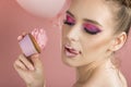 Fashionable pink make up. Girl with professional makeup in pink tones. Woman licks her lips. Skincare concept