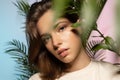 Fashionable portrait of a beautiful girl with perfect skin with tropical plants Royalty Free Stock Photo