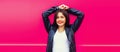 Fashionable portrait of beautiful smiling young brunette woman model posing in black leather jacket on pink background Royalty Free Stock Photo