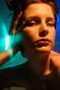 Fashionable portrait of emotional young beautiful woman with raised up short hair. Colorful fashionable neon light, blue Royalty Free Stock Photo