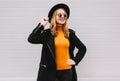 Fashionable portrait stylish happy smiling young woman having fun female model posing wearing a black coat, round hat on city Royalty Free Stock Photo