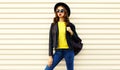 Fashionable portrait stylish young woman model posing wearing a black rock style jacket, yellow sweater, backpack on white Royalty Free Stock Photo
