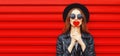 Fashionable portrait stylish young woman with red heart shaped lollipop blowing her lips sending sweet air kiss wearing a black Royalty Free Stock Photo