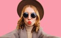 Fashionable portrait of stylish young woman stretching hand for taking selfie with smartphone blowing her lips with red lipstick Royalty Free Stock Photo