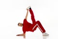 Fashionable portrait. Stylishly dressed man dancing in freestyle, breakdance style in motion against white background.