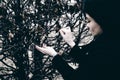 Fashionable portrait of a young brunette woman in black clothes, jeans T-shirt, coat and sunglasses, in a Gothic style sad mood Royalty Free Stock Photo