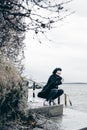 Fashionable portrait of a young brunette woman in black clothes, jeans T-shirt, coat and sunglasses, in a Gothic style sad mood Royalty Free Stock Photo