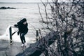 Fashionable portrait of a young brunette woman in black clothes, jeans T-shirt, coat and sunglasses, in a Gothic style sad mood Royalty Free Stock Photo