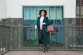 Fashionable portrait of young woman in emerald dress, white knitted sweater and Marsal hat Royalty Free Stock Photo