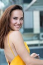 Fashionable pretty stylish girl posing outside. Street fashion. Beautiful young brunette smiling woman wearing yellow dress Royalty Free Stock Photo