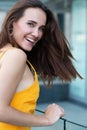 Fashionable pretty stylish girl posing outside. Street fashion. Beautiful young brunette woman wearing yellow dress happy smiling Royalty Free Stock Photo