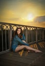 Fashionable redhead in blue blouse and long legs laying down on a wooden bridge. Beautiful girl with long hair posing, outdoors Royalty Free Stock Photo