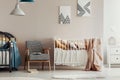 Retro armchair between two wooden cribs in cute twins nursery