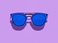 Vintage styled simple blue sunglasses on purple backgrpond. Royalty Free Stock Photo