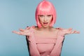 Fashionable shocked girl in pink wig posing with shrug gesture isolated