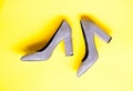 Fashionable shoes concept. Shoes made out of grey suede on yellow background. Footwear for women with thick high heels Royalty Free Stock Photo