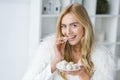 fashionable smiling woman in fur coat eating Royalty Free Stock Photo