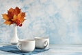 Fashionable stock autumn background - yellow leaves, red berries and a cup on blue. Royalty Free Stock Photo