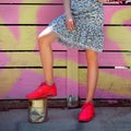 Fashionable street style female outfit with red sport sneakers and casual dress.