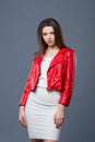 Fashionable style, fashion women`s clothing, color combination. Beautiful brunette girl in white dress and red leather jacket