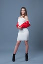 Fashionable style, fashion women`s clothing, color combination. Beautiful brunette girl in white dress and red leather jacket