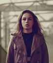 Fashionable style female model in fashion clothing posing in brown jacket on autumn style background on the street. Autumn