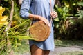 Fashionable stylish rattan bag in the tropical garden.