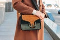 Fashionable stylish woman in a beige coat with a trendy suede bag