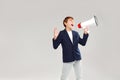 Fashionable teenager boy screaming through megaphone in studio. A lot of copy space Royalty Free Stock Photo