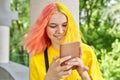 Fashionable teenager girl with colored dyed hair with a smartphone outdoors. Royalty Free Stock Photo