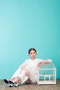 fashionable teenager in white with parrot in cage