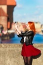 Fashionable tourist girl taking picture with camera old town Gdansk Royalty Free Stock Photo