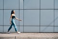 Fashionable trendy african american woman walking along street wall urban background Royalty Free Stock Photo