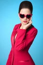 Fashionable trendy brunette wearing in heart sunglasses and red