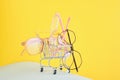 fashionable trendy eyes glasses for correction of vision in a shopping trolley on a colorful background, geometric