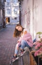 Fashionable trendy stylish young girls in white T-shirt, jeans, cozy pink knitted sweater posingin the city