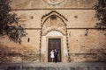 Fashionable wedding couple near Catholic church. Bride and Groom. Outdoor portrait Royalty Free Stock Photo